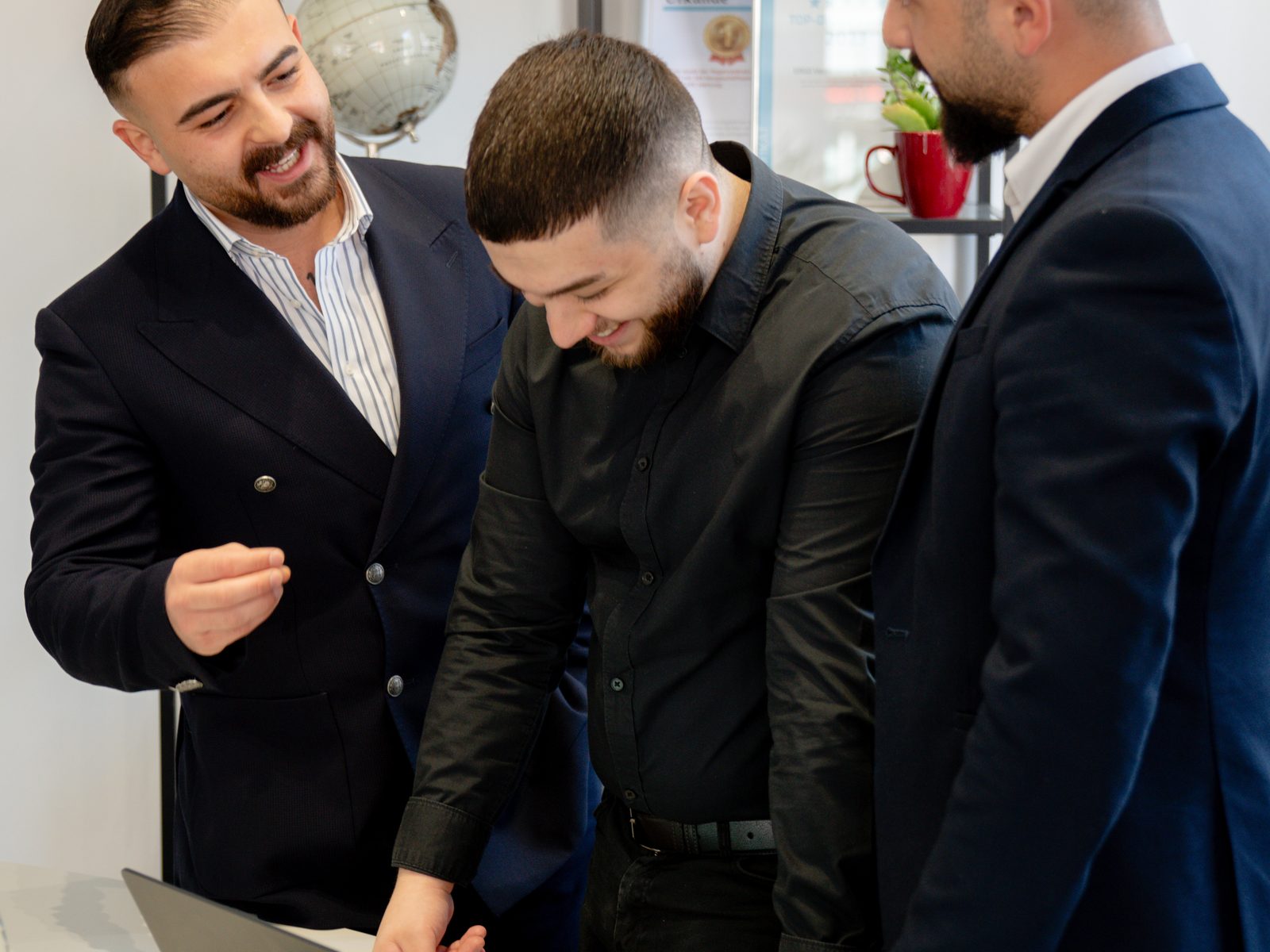 Teammitglieder besprechen eine Gewerbeversicherung am Laptop